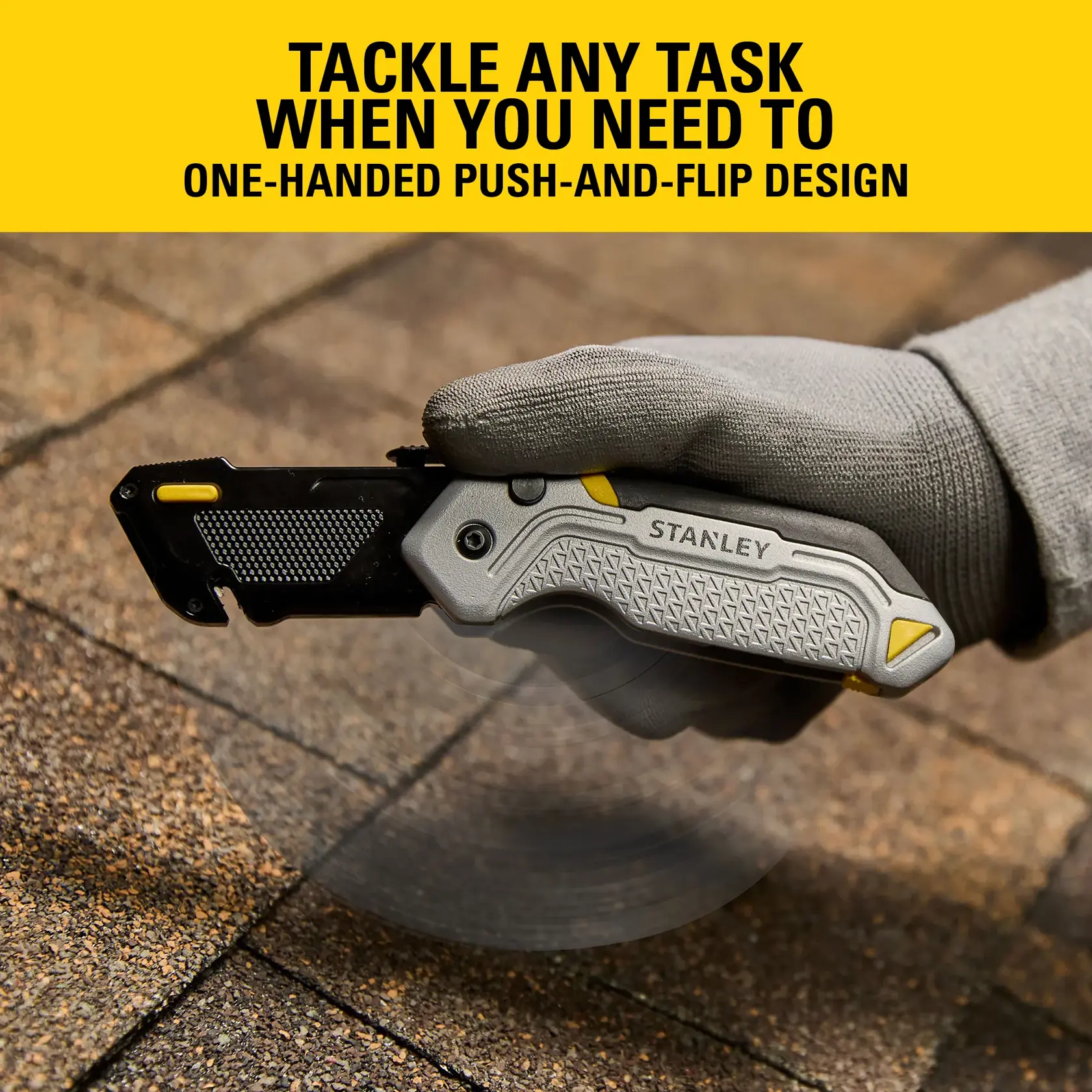 Stanley push-and-flip utility knife being used on shingles by a gloved hand. One-handed operation design.