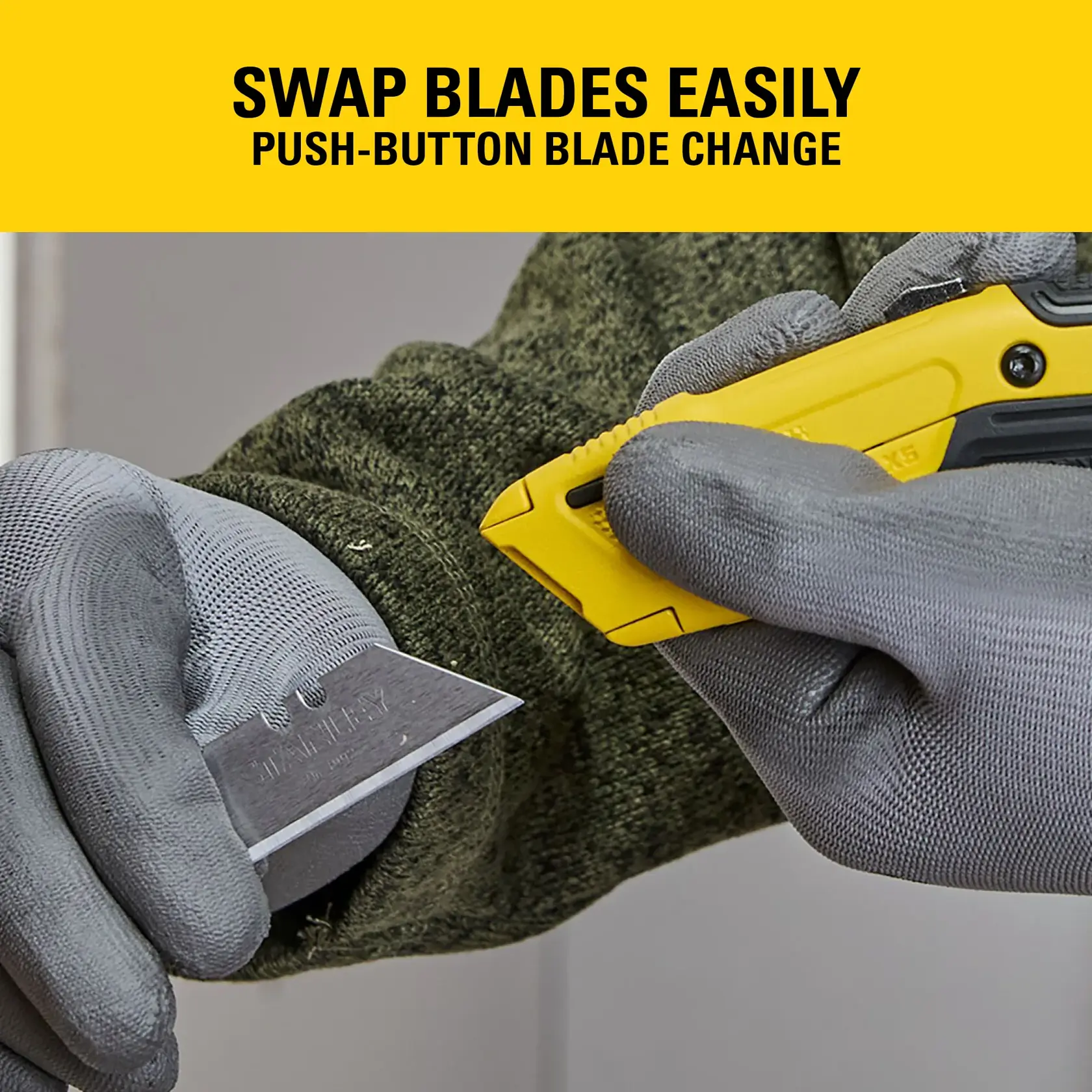 Gloved hands swapping blade on yellow STANLEY utility knife, push-button mechanism shown.