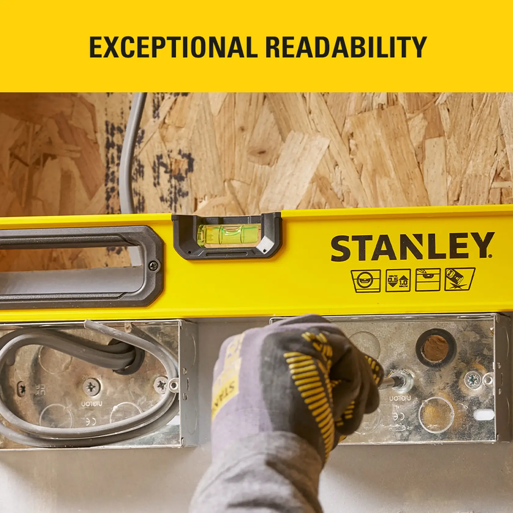 Photo of STANLEY level tool STHT41024-0 in use, showing bubble vial and glove, photographed from top angle.