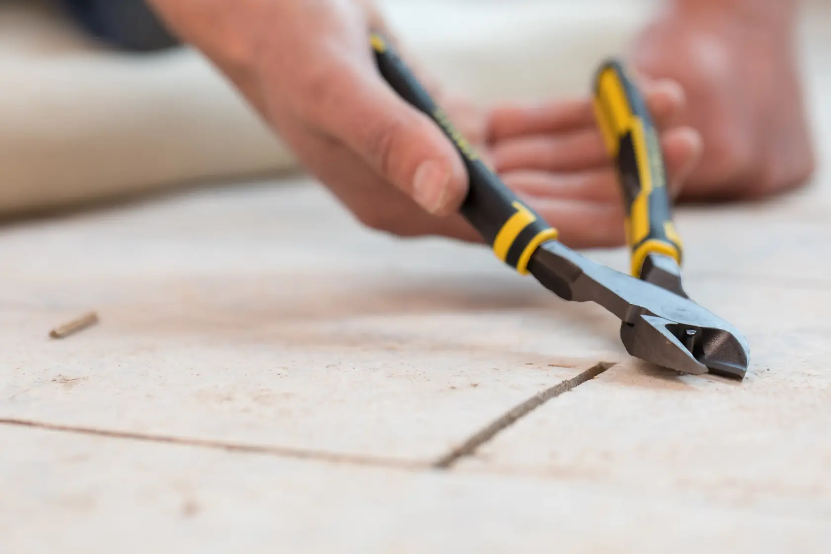 STANLEY 89-861 diagonal cutting pliers with yellow and black handle in use on tiled floor.