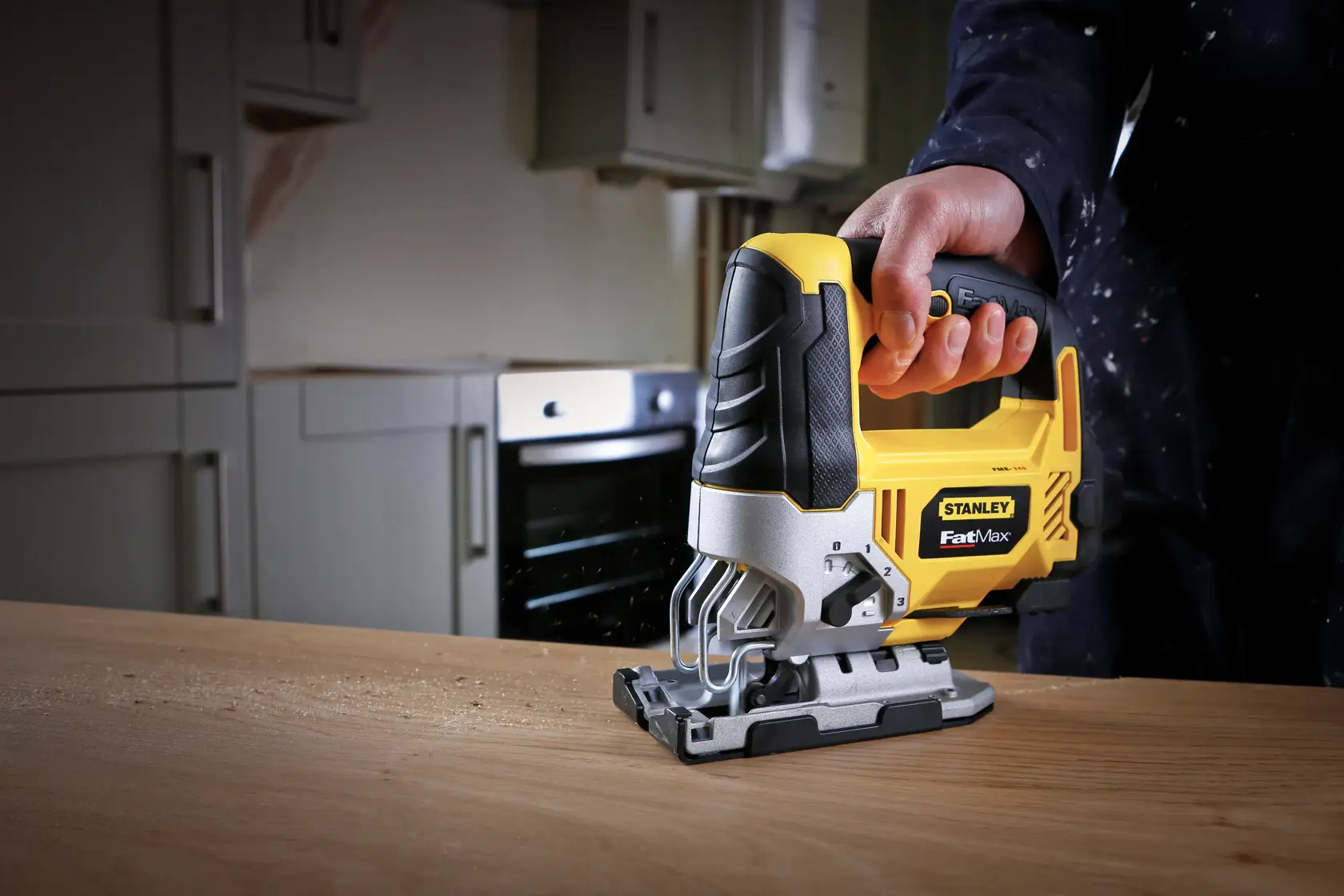 STANLEY FME340K jigsaw power tool in use on wood, close-up angle, yellow and black design.