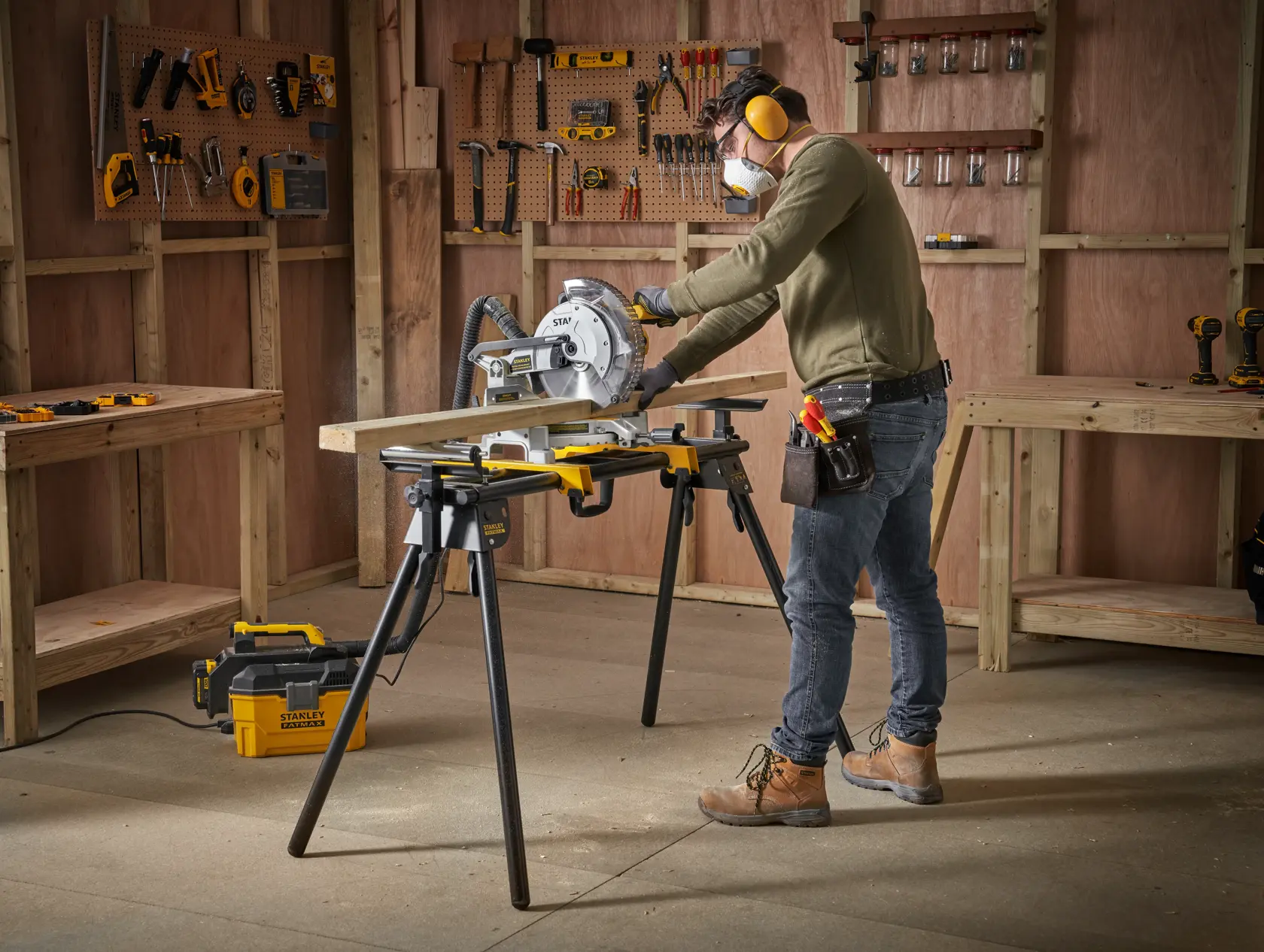 STANLEY FME790-XJ miter saw in use on workbench, man cutting wood in workshop.