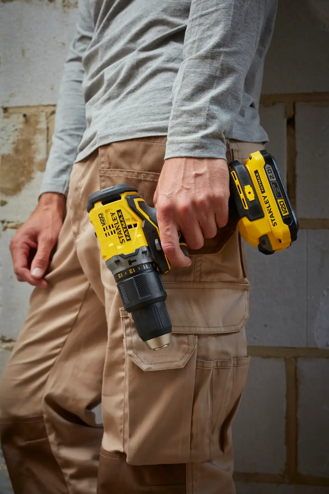 STANLEY SFMCD715D1A cordless drill driver held in right hand, side view, with yellow and black design.