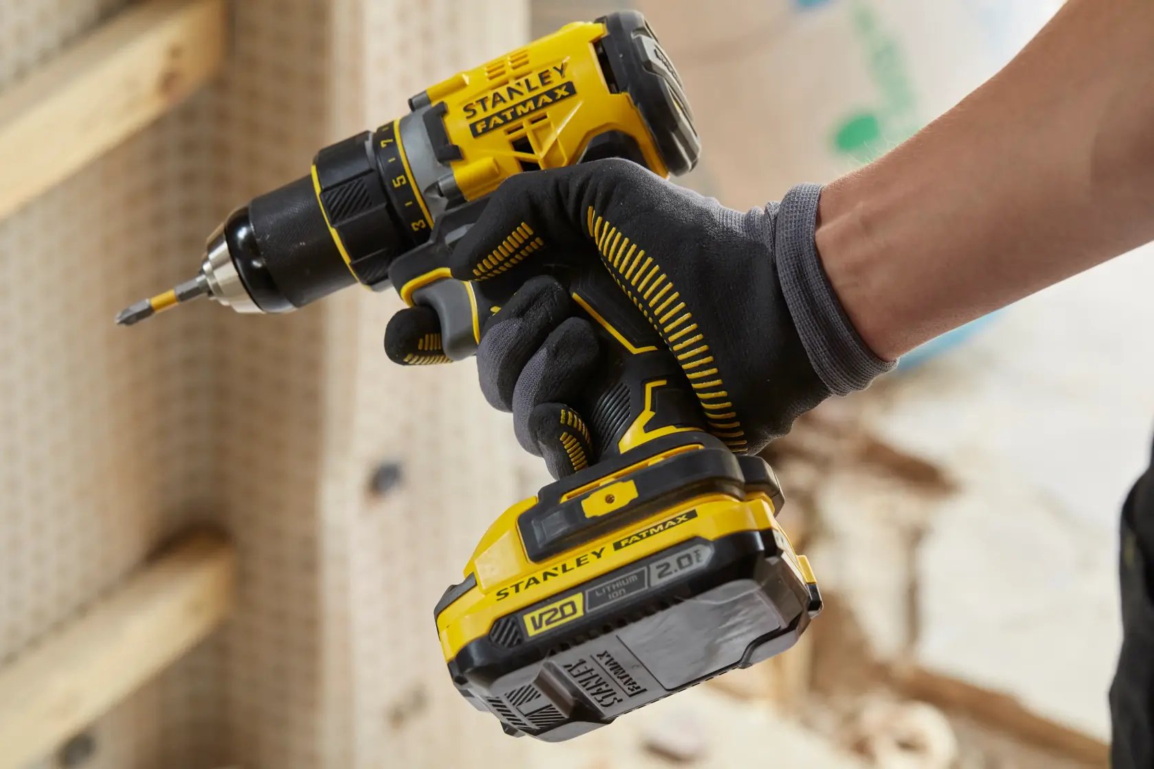 Photo of STANLEY SFMCD720DR2 cordless drill driver in use, yellow and black design in worksite setting.