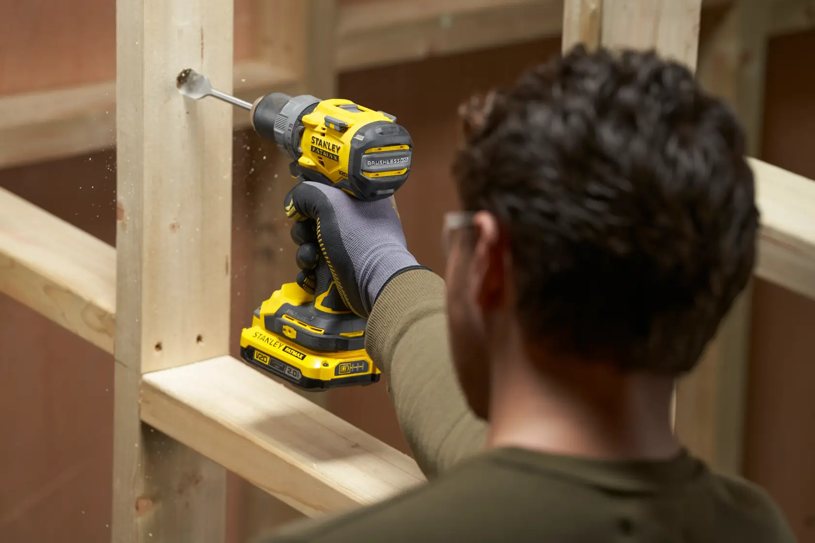 Photography of STANLEY SFMCD725B cordless drill in use drilling wood.