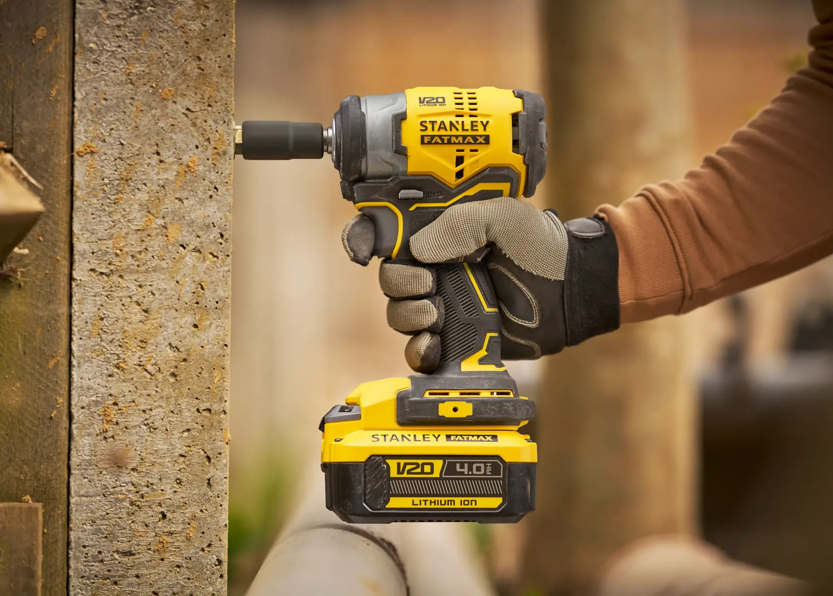 Photo of STANLEY SFMCF910B impact driver in use, yellow and black design, V20 4.0Ah lithium ion battery.