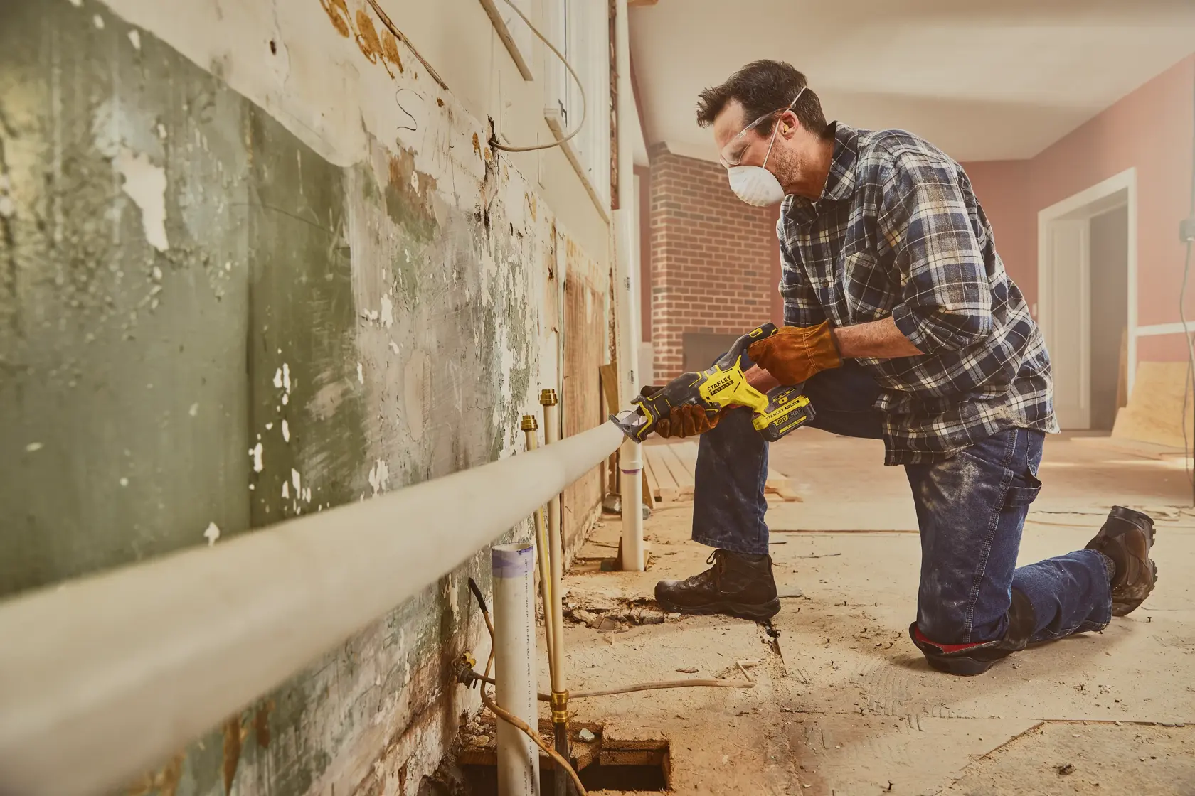 STANLEY SFMCG700B cordless grinder used by worker cutting pipe in construction site, side angle.