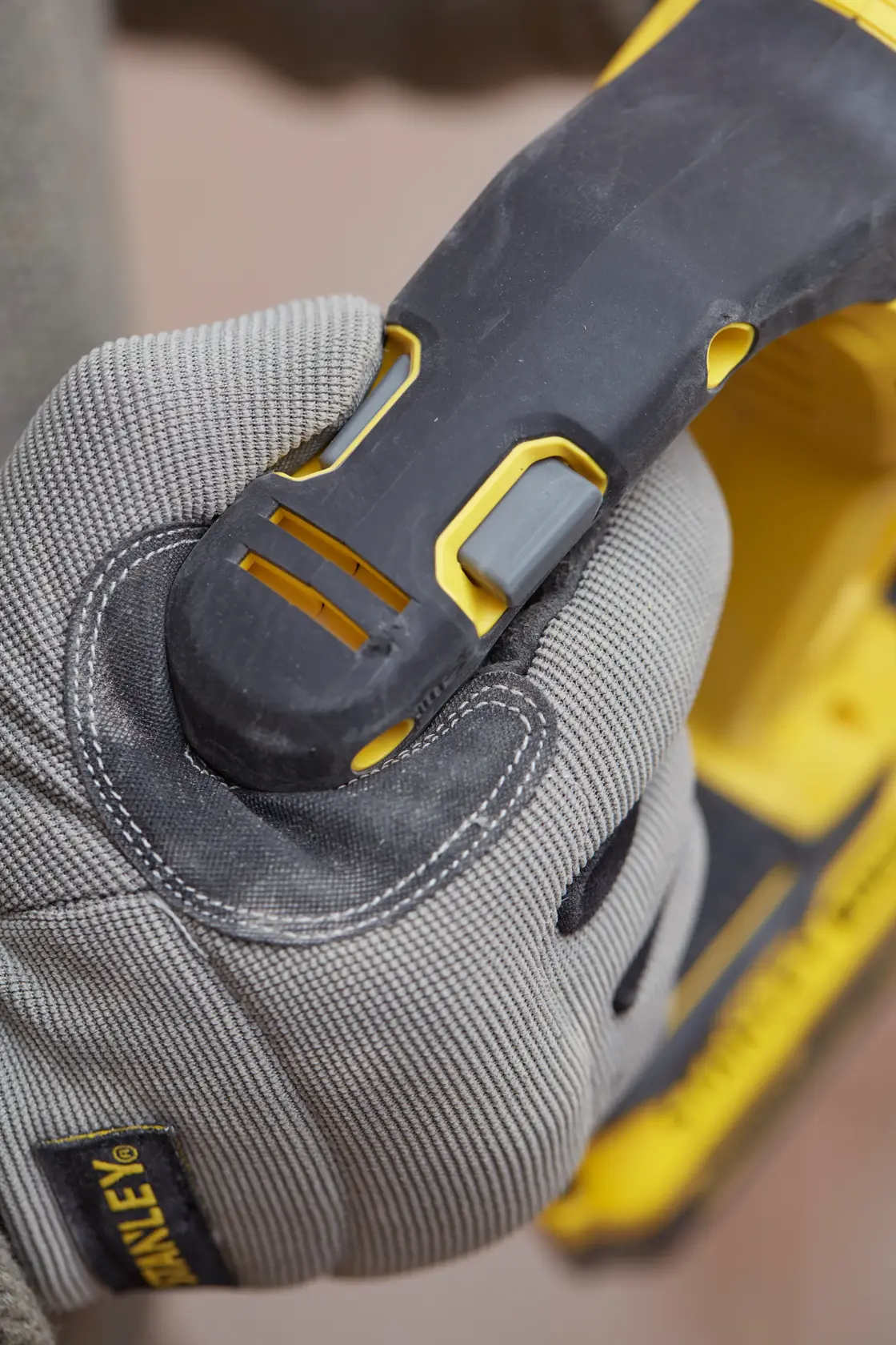 STANLEY SFMCH900B power tool handle held by gloved hand, close-up photography.