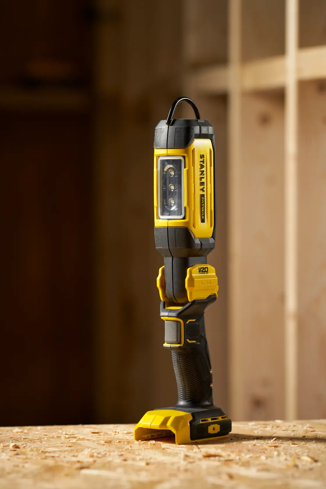 STANLEY SFMCL050B 18V FATMAX V20 Pivot Light, yellow-black LED work light, shown upright on wood surface.