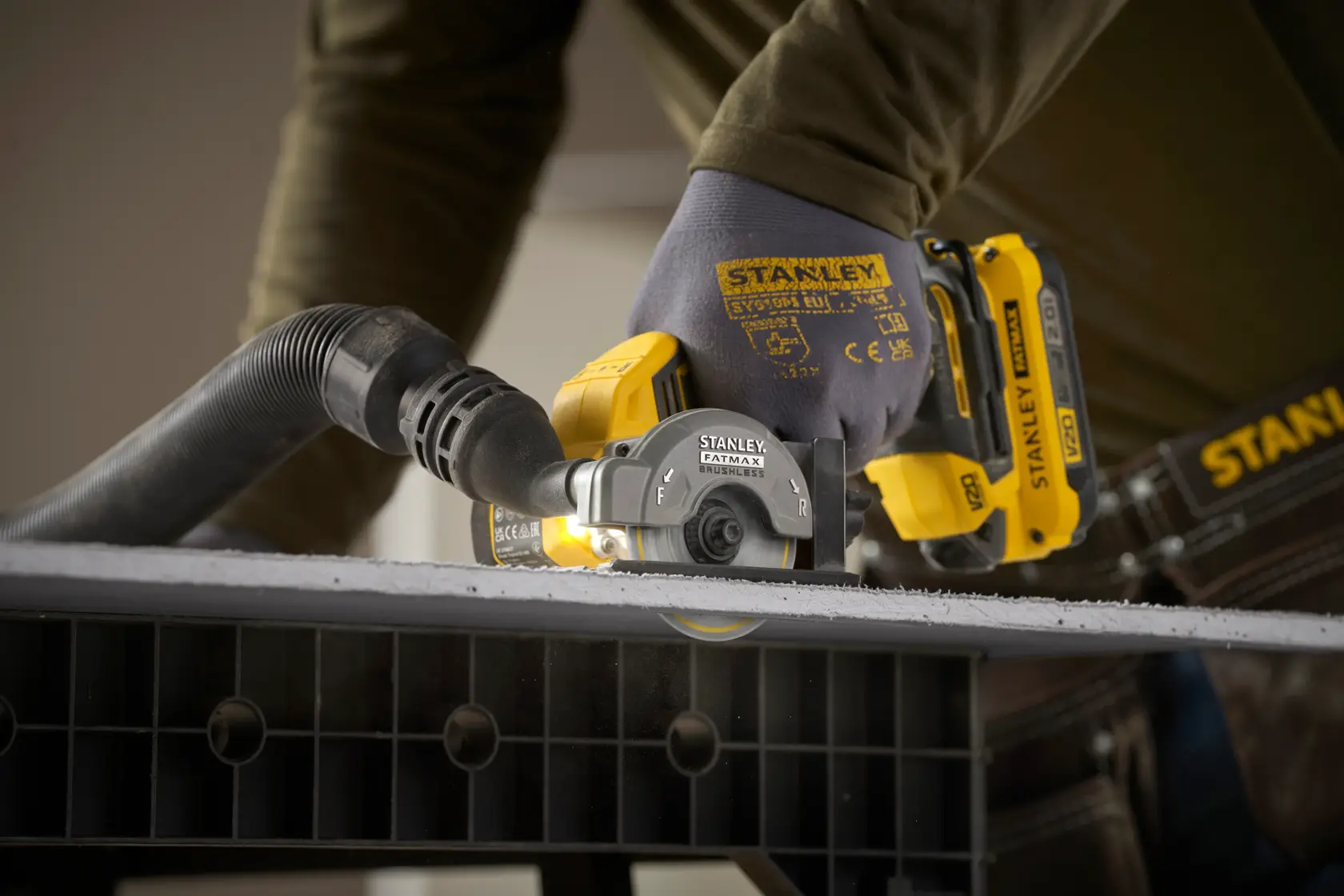 STANLEY SFMCM300B cordless cut-off tool in use cutting material, close-up side angle photography.