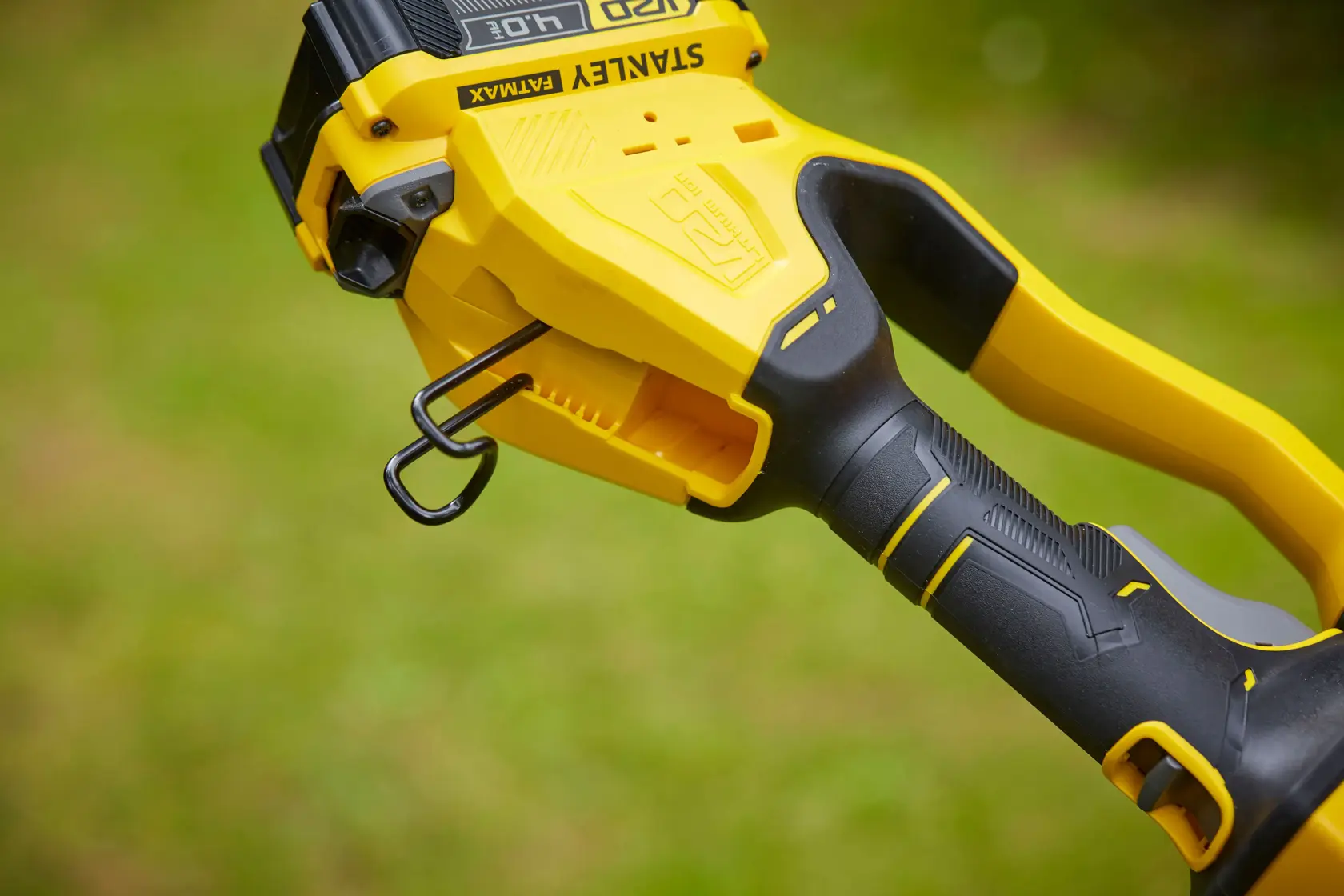 STANLEY SFMCPS620B grass trimmer handle close-up showing yellow and black ergonomic grip and belt hook.