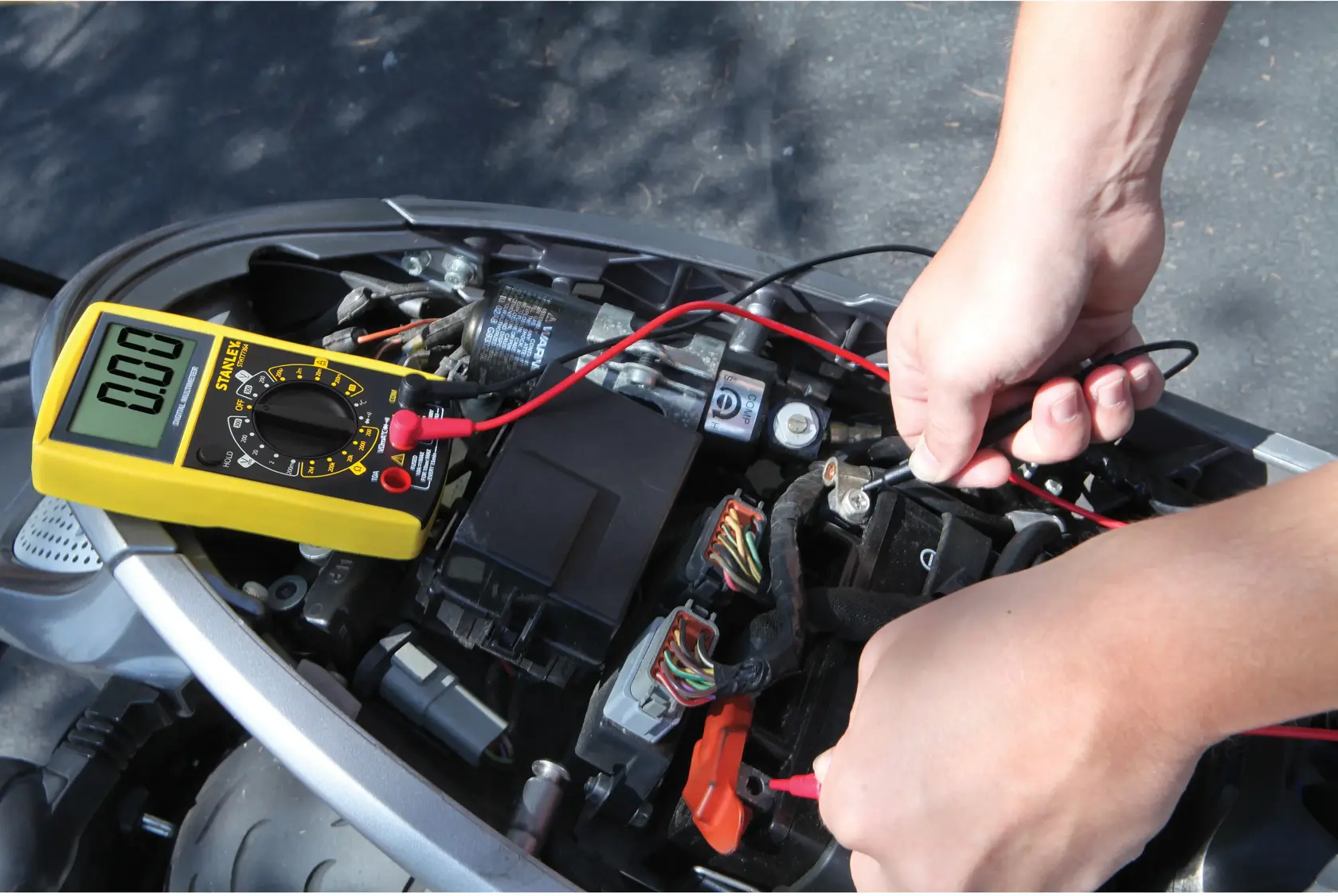 STANLEY STHT0-77364 digital multimeter testing vehicle wiring, yellow device, photography category.