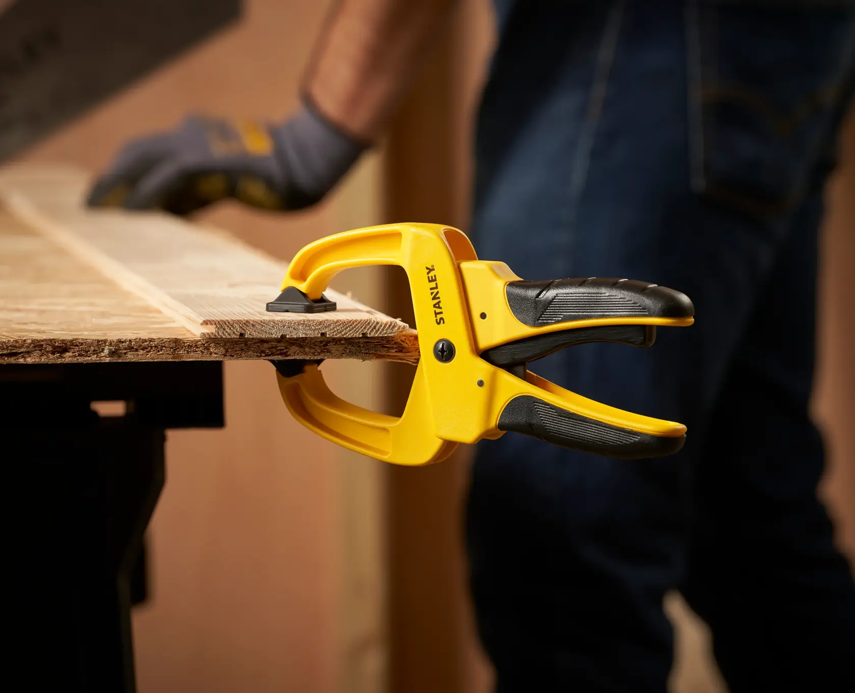 STANLEY STHT0-83199 photography of yellow and black clamp holding wood board, side angle.