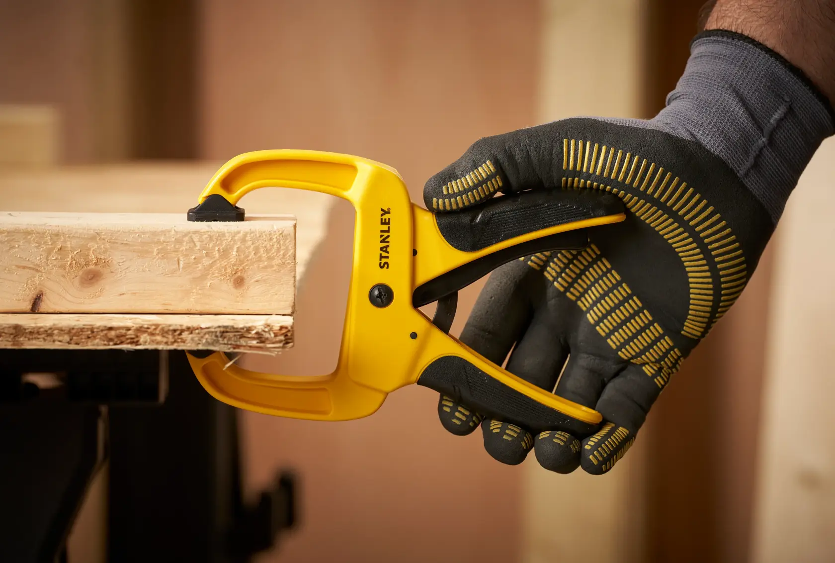 STANLEY STHT0-83199 yellow clamp being used to secure wood, close-up side view.