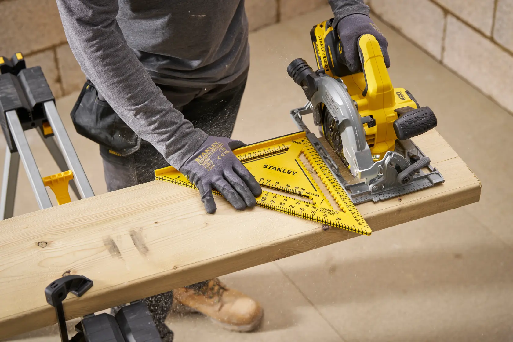 STANLEY STHT46013-0 yellow plastic rafter square used for marking wood in workshop setting.