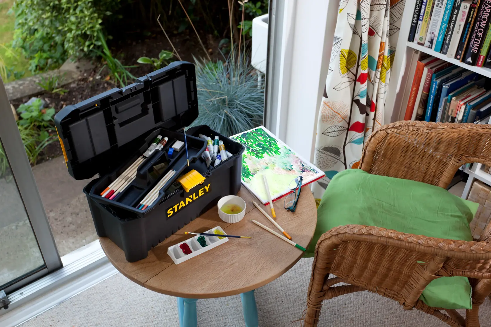 STANLEY STST1-75517 tool box used for art supplies on table, watercolor set and brushes, indoor photography.