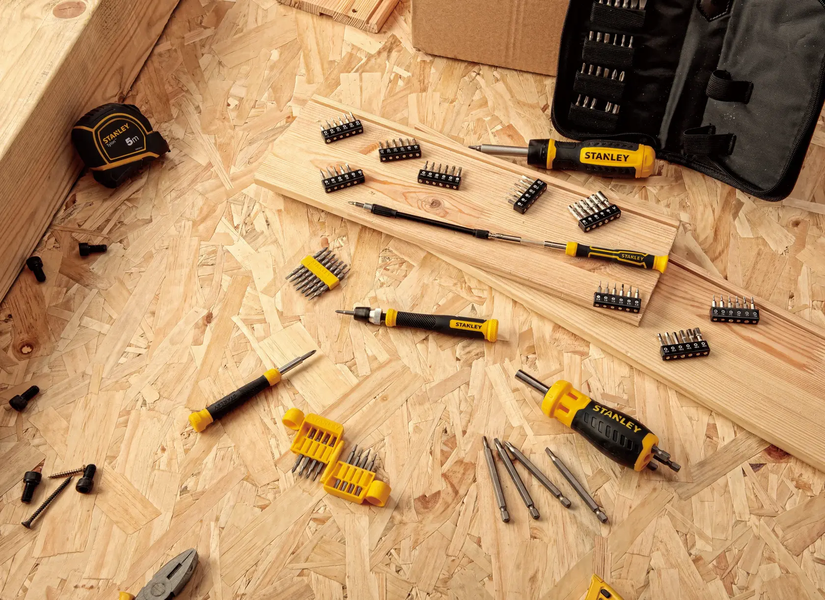 STANLEY FMHT60089-LA screwdriver set with multiple bits on wood surface, tools and accessories visible.